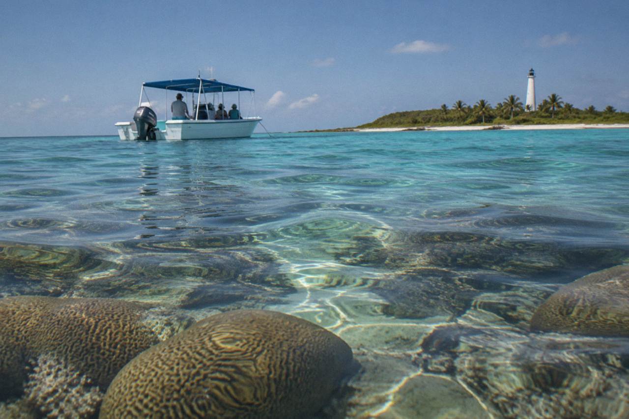 Clear shallow water over a coral reef with a boat anchored nearby