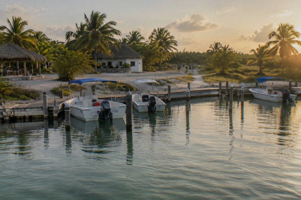 A private marina dock at Punta Sam with speedboats moored in calm water