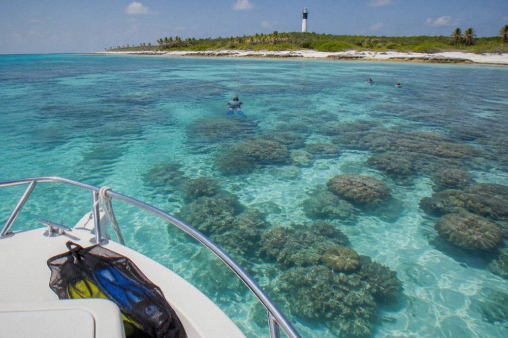 Snorkel boat moored over a shallow coral reef in clear Caribbean water