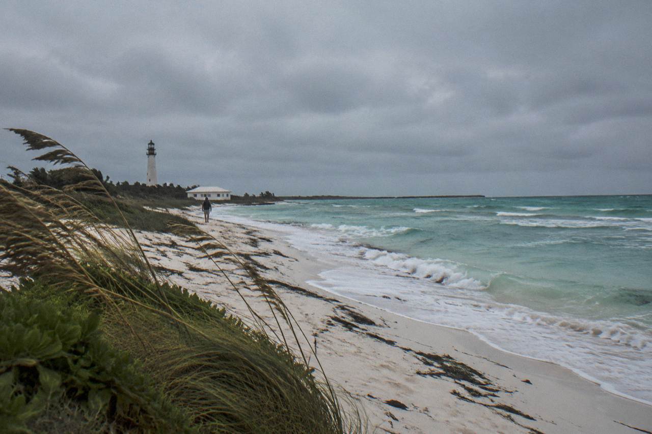 Empty white sand beach on a small Caribbean island under a grey winter sky with low waves