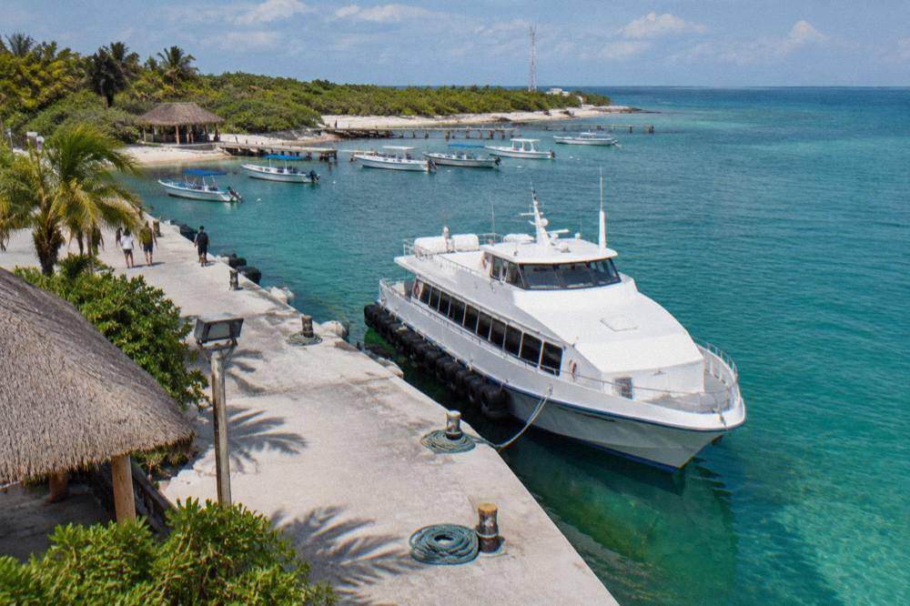 Passenger ferry docked at a pier with moored boats in calm water