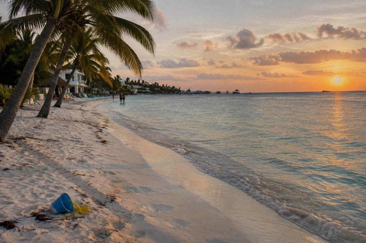 Quiet white sand beach beside calm turquoise water along Isla Mujeres