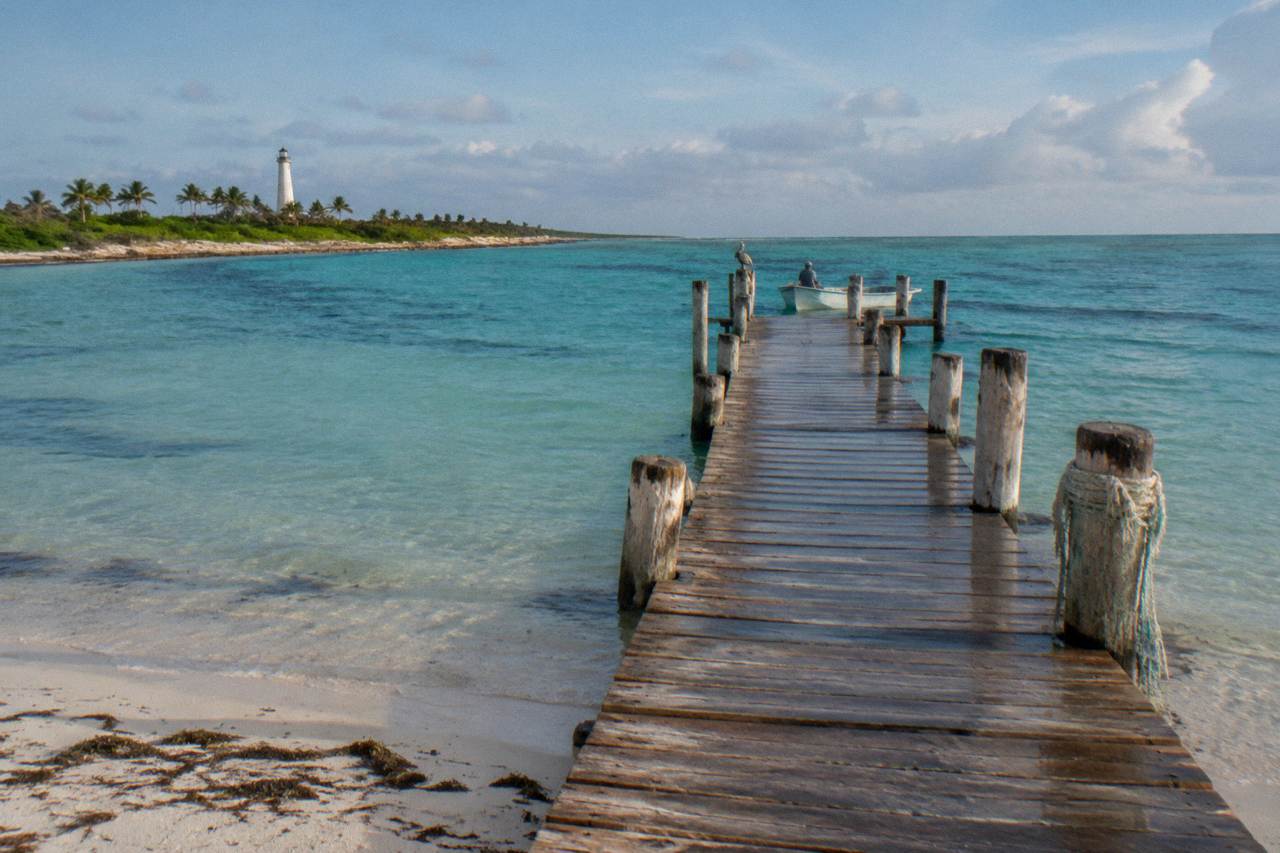 Wooden dock and turquoise shallow water at a small Caribbean island shoreline