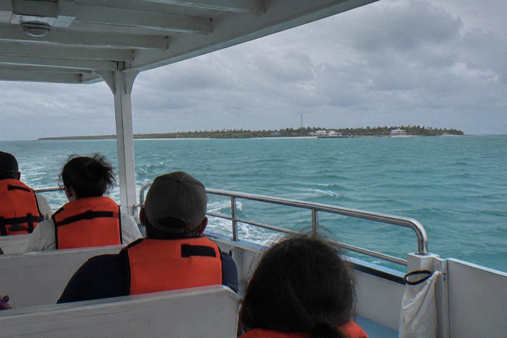 Passengers in life vests seated on a boat deck during an open-water crossing