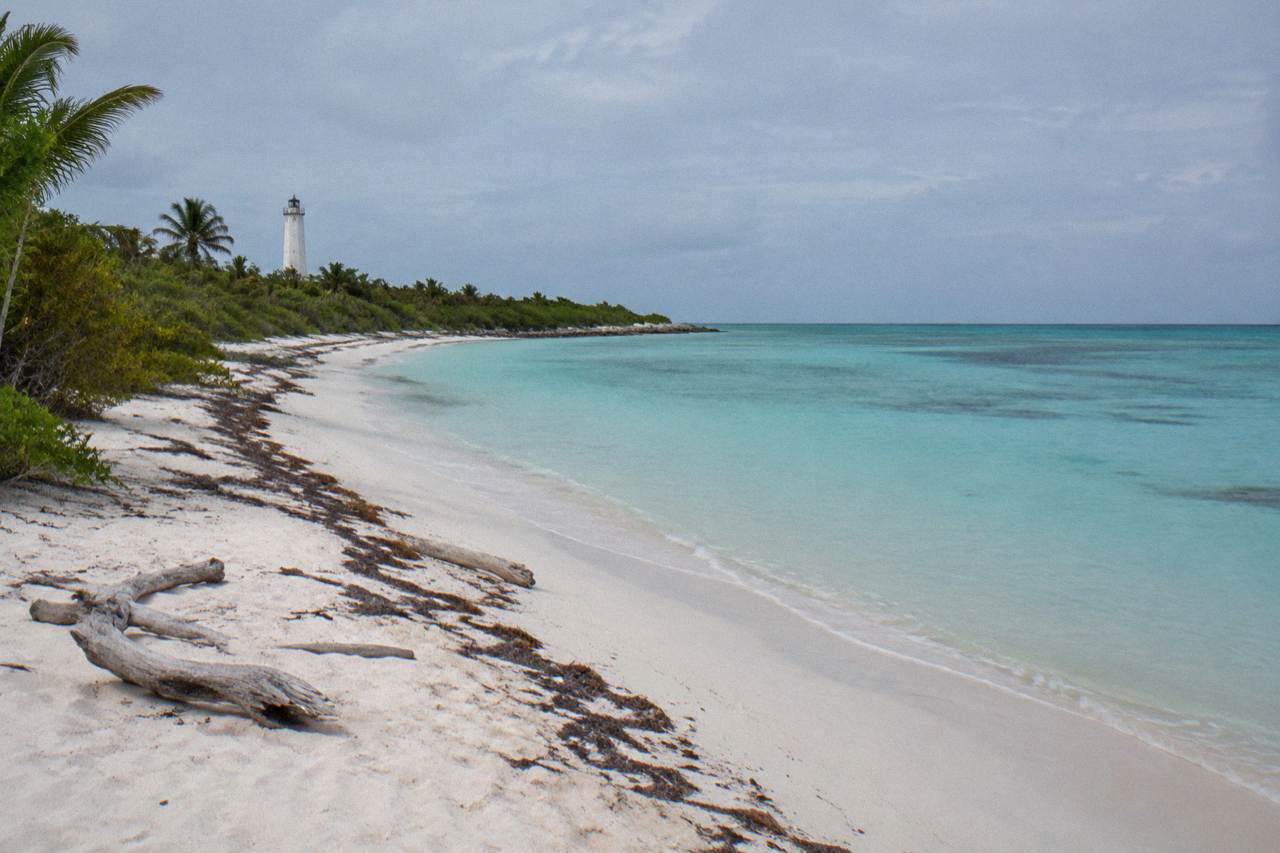 Empty white sand beach and calm turquoise water at a protected island shoreline
