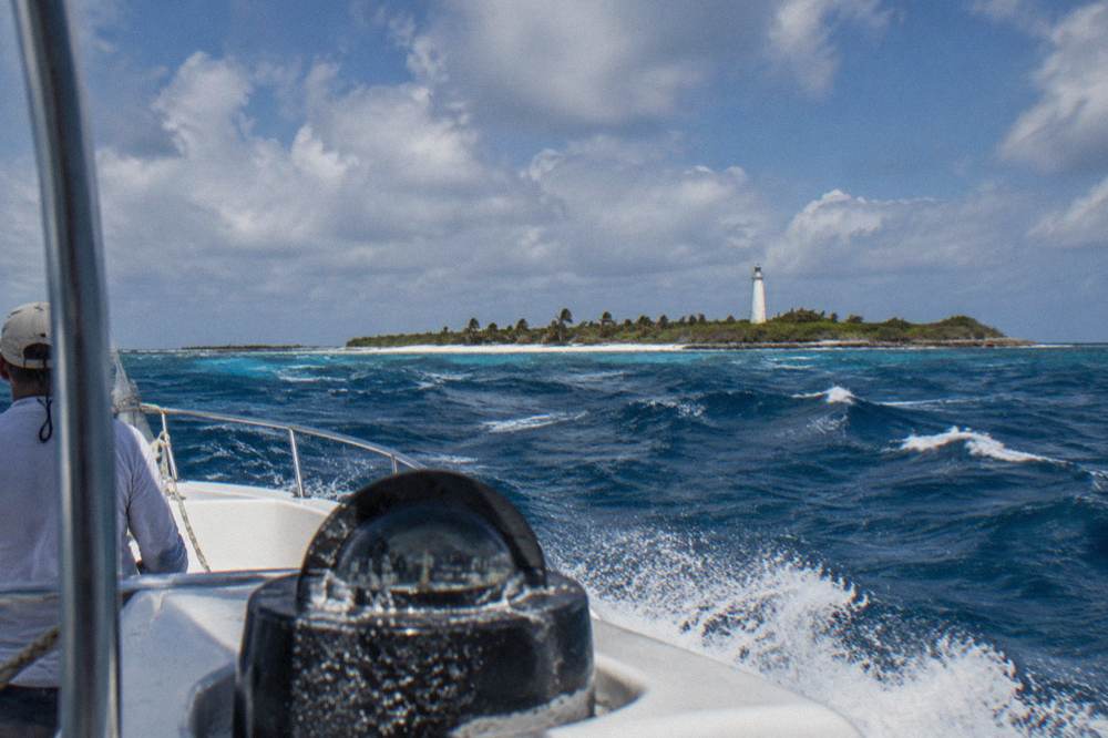 Open Caribbean water with whitecaps under a partly cloudy sky seen from a boat deck