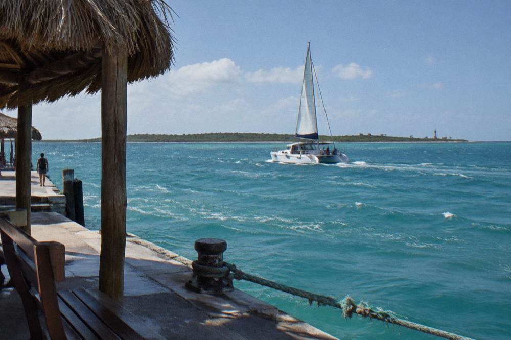 A catamaran under way on open water between two islands