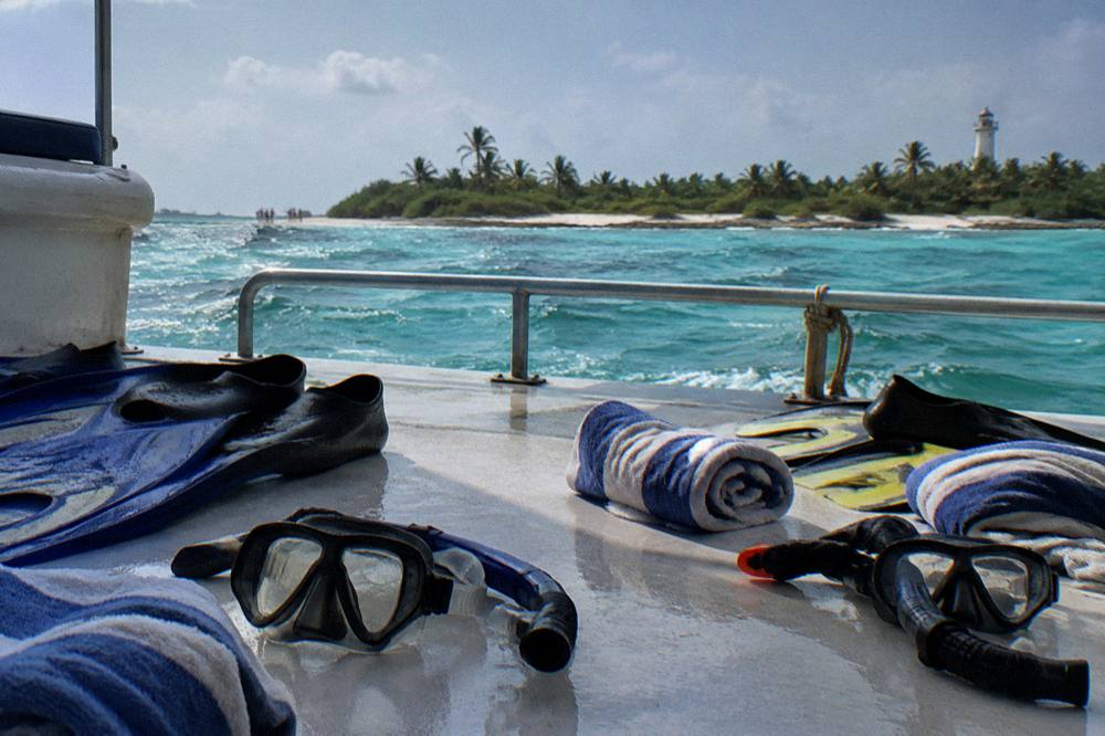 Snorkel gear and towels laid out on a boat deck before a reef stop