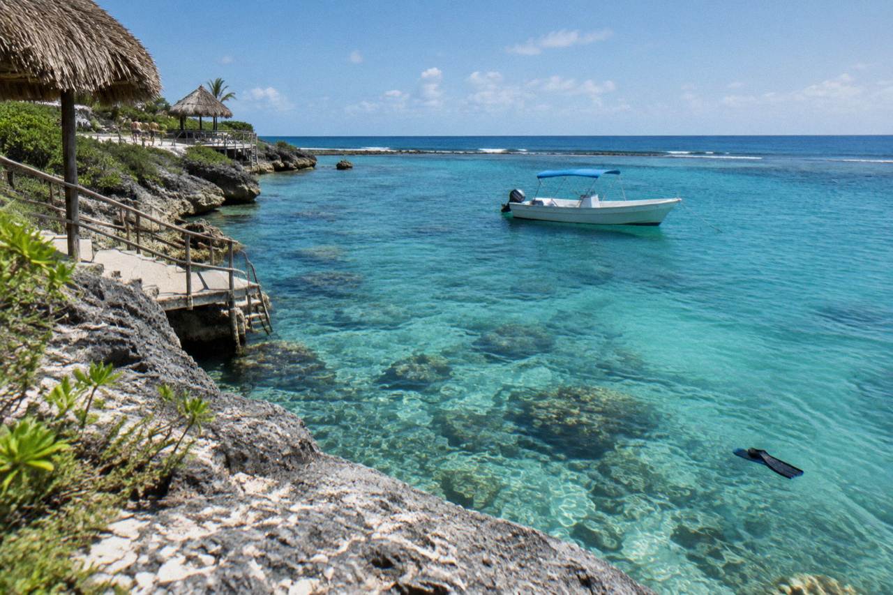Calm turquoise water over a shallow coral reef with a boat anchored nearby