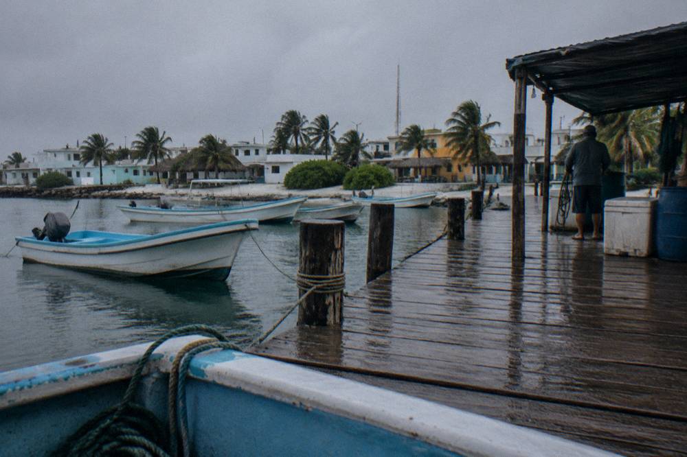 Small fishing-town dock on Isla Mujeres with moored boats and calm morning water