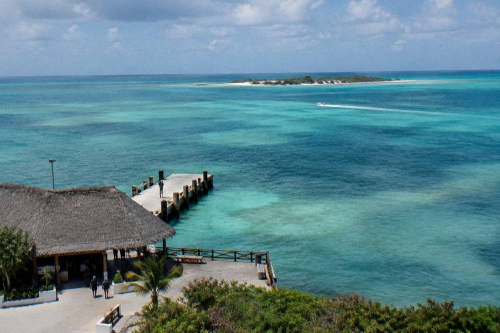Map-like aerial view of the coastline between Cancun and Isla Mujeres with a low sandbar island on the horizon